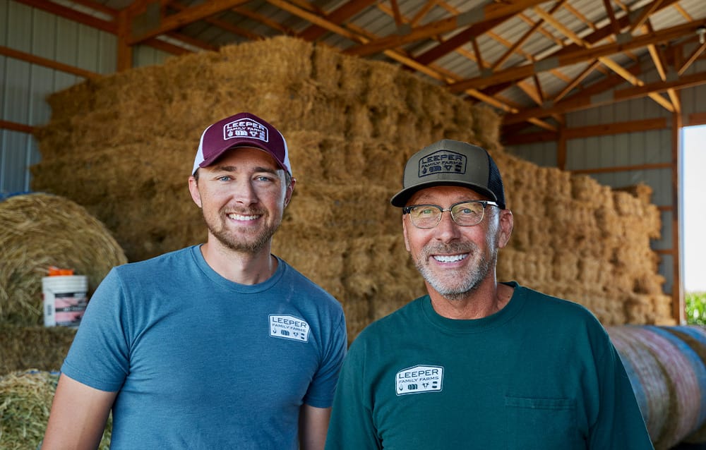 Two producers standing in a barn