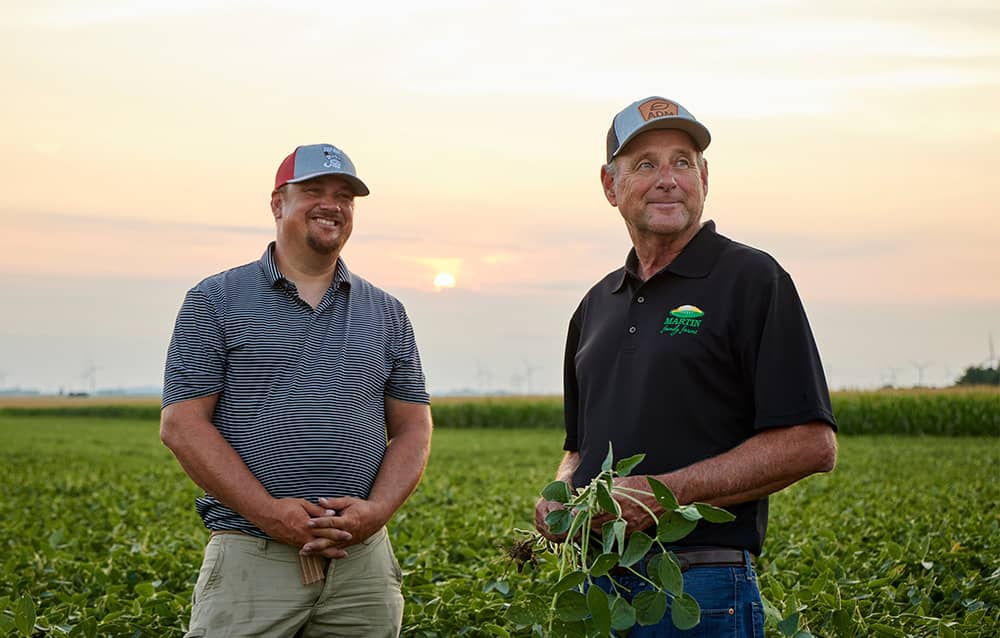 Two producers standing in a soybean field