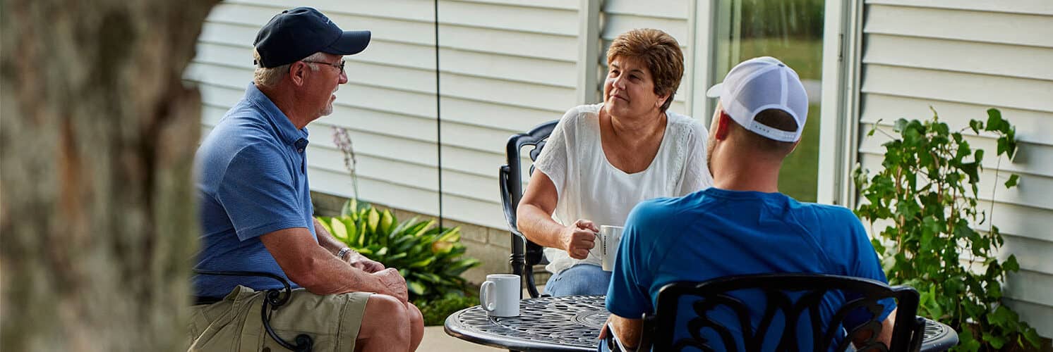 Myers family sitting on patio furniture in discussion