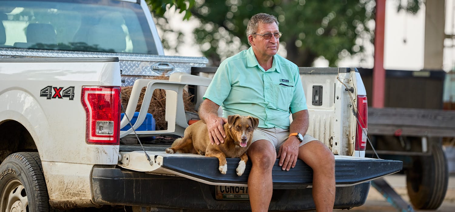Producer, Donald Chase and his dog sitting in the back of a truck