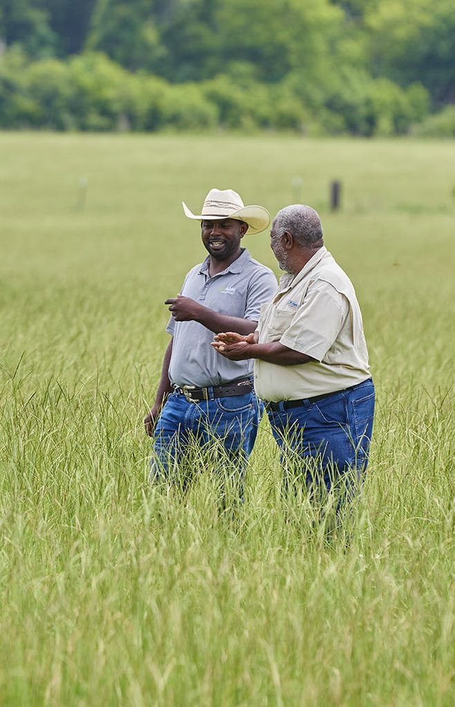 ADM rep wearing a cowboy hat talking to a producer in a field