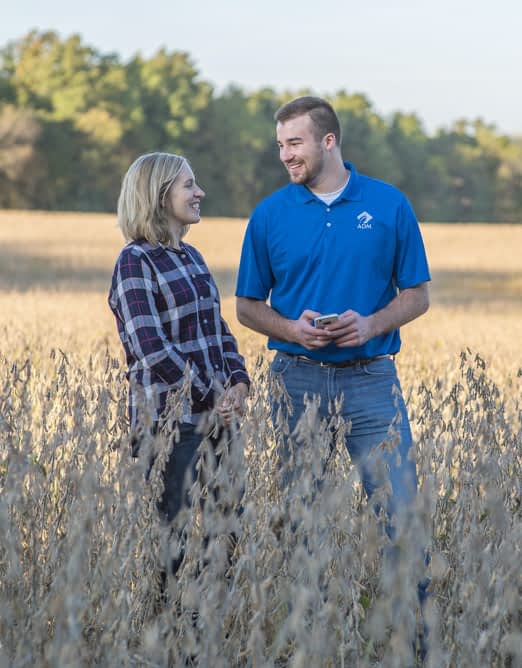 Producer and ADM representative talking in soybean field